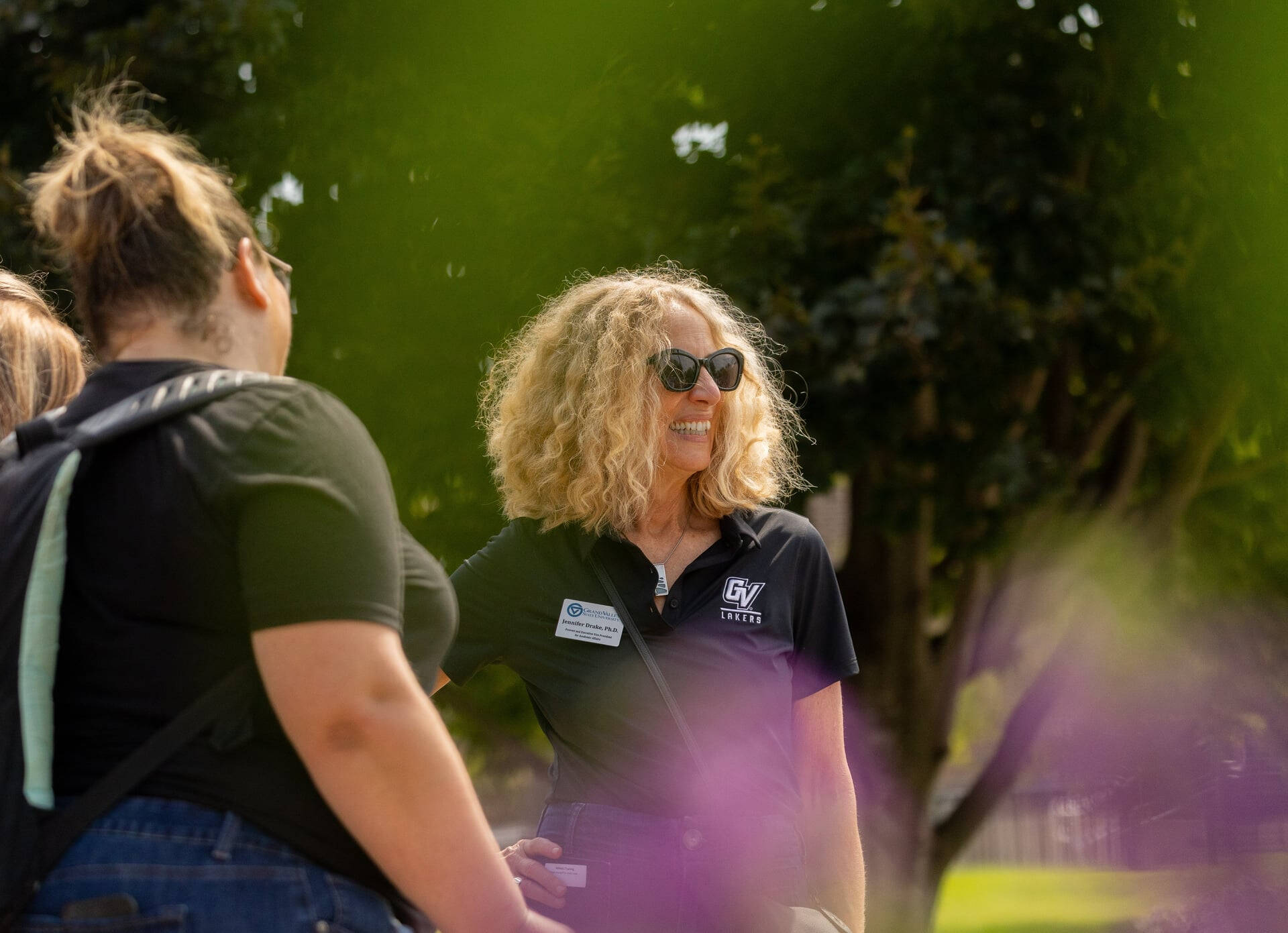 Provost Jennifer Drake in a black GVSU polo shirt and sunglasses